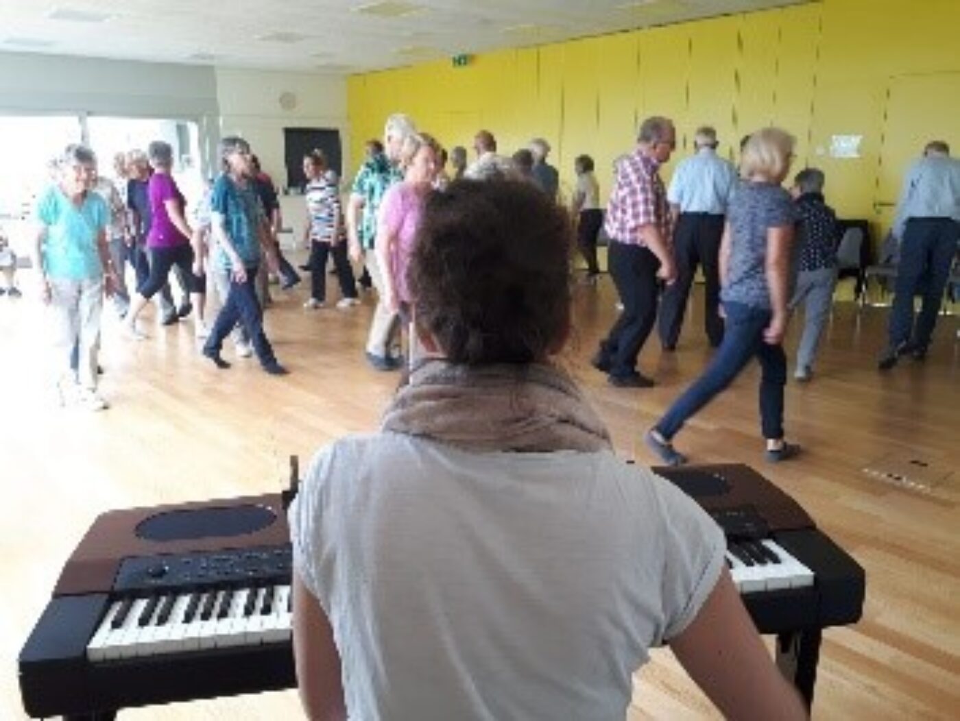 Gruppe hinter einem Klavier beim Tanzen